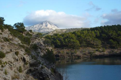 a mountain in the distance with a body of water at La Ferme in Saint-Marc-Jaumegarde