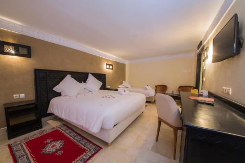 a hotel room with a large bed and a television at Zalagh Kasbah Hotel & Spa in Marrakech