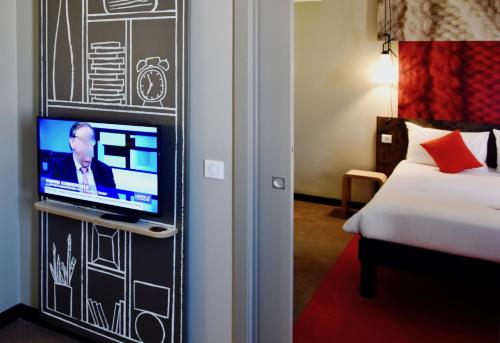 a room with a bed and a tv on a wall at Ibis Sfax in Sfax