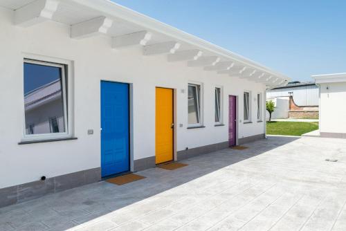 a row of colorful doors on a white building at B & b Venere in Paestum