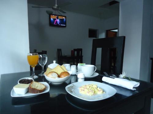 a table with plates of food on a table with drinks at HOTEL Casa cesar in Tumbes