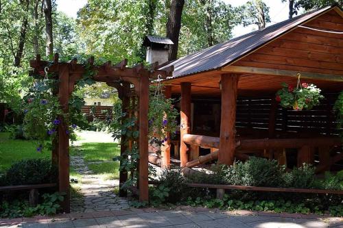 a wooden pavilion with a gazebo with flowers at Veniki-Club in Vorzel