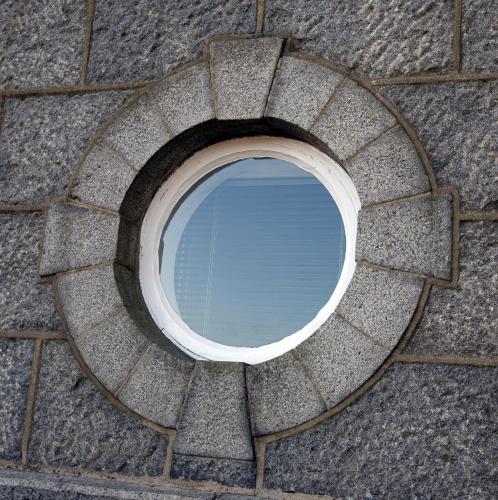 a circular window in a brick wall at Aberdeen Serviced Apartments - The Lodge in Aberdeen