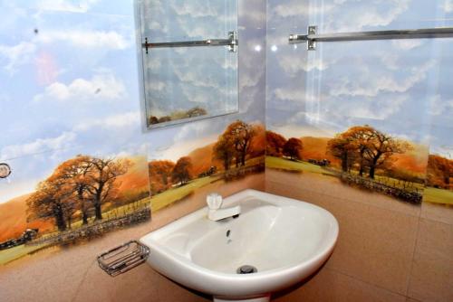 a bathroom with a sink and a window with trees at Green Heritage Holiday Resort in Mahiyangana