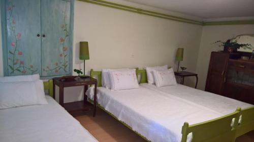 a bedroom with two beds with white sheets and a dresser at Spitaki Spata Airport Studio in Spáta