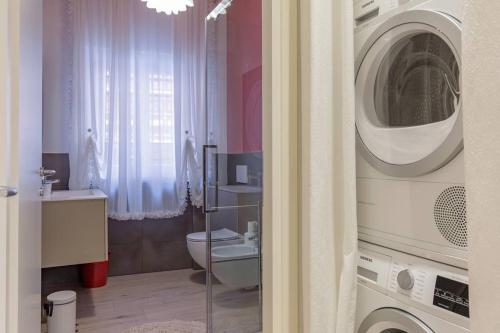 bagno con servizi igienici e lavatrice. di Verona's Apartment near the Arena a Verona