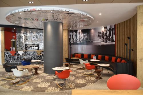 a restaurant with tables and chairs in a lobby at Ibis Sfax in Sfax