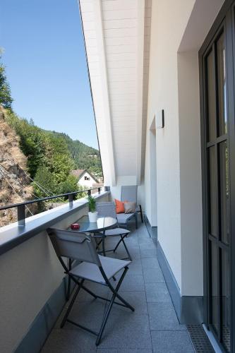 a balcony with a table and chairs on a building at Hotelmyhome in Hornberg