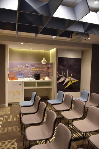 a waiting room with chairs and a painting on the wall at Ibis Sfax in Sfax