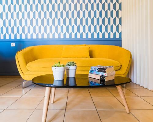 a living room with a yellow couch and a coffee table at Sunshine Studios in Malia
