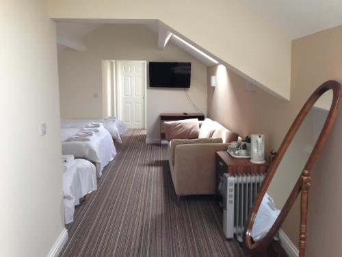 バロー・イン・ファーネスにあるAmbrose Hotelのベッドとソファのあるホテルの部屋