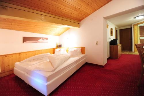 a bedroom with a large white bed in a room at Hotel Toni in Galtür