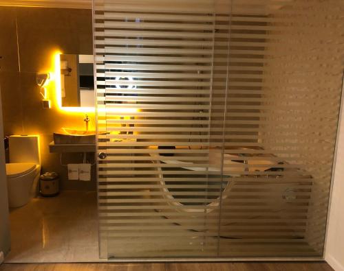 a bathroom with a glass shower with a sink at Hotel Brais in Durrës
