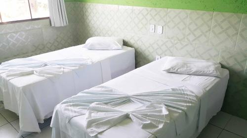 two beds in a room with bows on them at Yves Hotel in Porto Velho