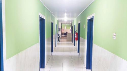 a hallway with green and white walls and blue doors at Yves Hotel in Porto Velho