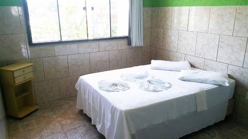 a bed with white sheets and white towels on it at Yves Hotel in Porto Velho
