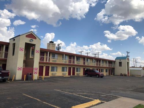 a building with a car parked in a parking lot at Lone Star Inn in Lubbock