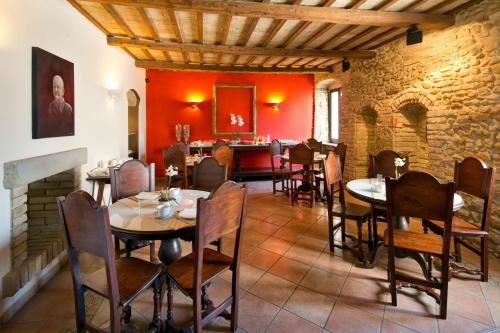 uma sala de jantar com mesas e cadeiras e uma parede de tijolos em Hotel Degli Affreschi em Montefalco