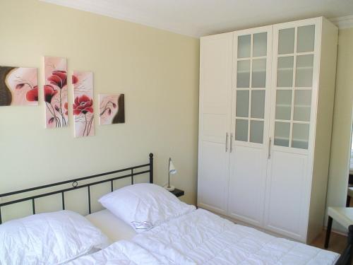 オストゼーバート・カールスハーゲンにあるMax und Moritzのベッドルーム1室(ベッド1台付)が備わります。壁には絵画が飾られています。