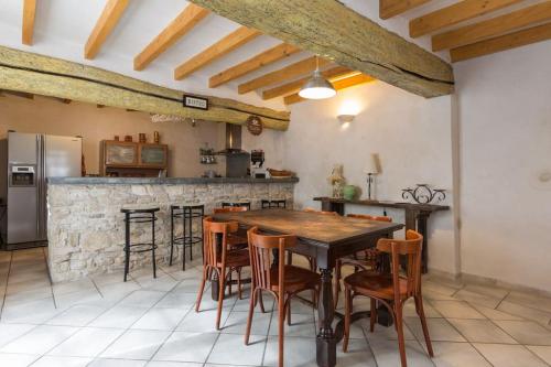 une cuisine avec une table et des chaises en bois dans l'établissement ** Lolile 1 **, à LʼIsle-sur-la-Sorgue