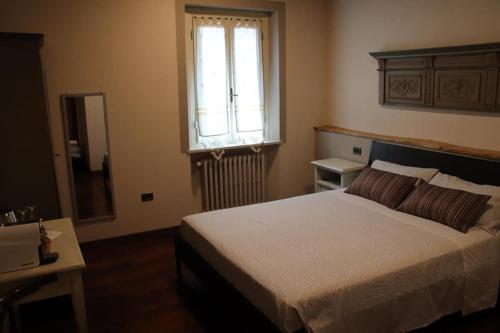 a bedroom with a large bed and a window at Bed & Breakfast 1906 in San Martino In Strada
