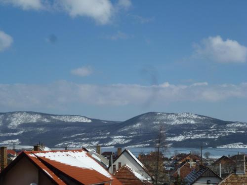 a city with snow covered mountains in the background at Edelweiss Panzió in Pilisvörösvár