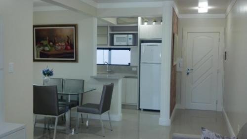 uma cozinha e sala de jantar com mesa e cadeiras em Apartamento 207, Edificio Kaluy em Florianópolis