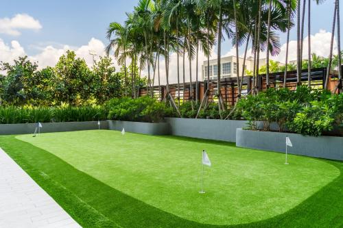 a grassy area with a green lawn and a tennis court at Hyde Suites Midtown Miami in Miami