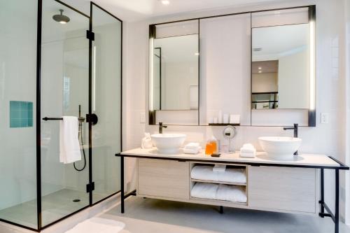 a bathroom with two sinks and a shower at Hyde Suites Midtown Miami in Miami