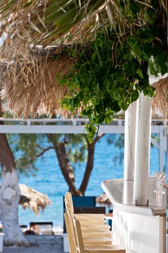 a table and chairs with a view of the water at Alesahne Beach Hotel in Kamari