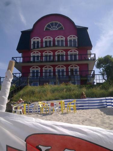 a large red building with yellow chairs on the beach at BAłTYK NAD MORZEM-PRZY PLAŻY in Niechorze