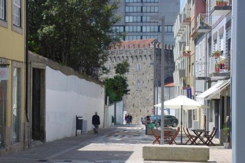a person walking down a city street with an umbrella at Art Gallery Apartment in Porto