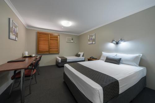 Säng eller sängar i ett rum på Cosmopolitan Motel & Serviced Apartments