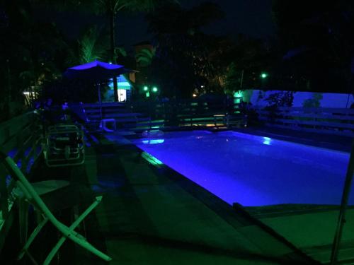 a swimming pool at night with blue lights at Alemao Cabanas in Camburi