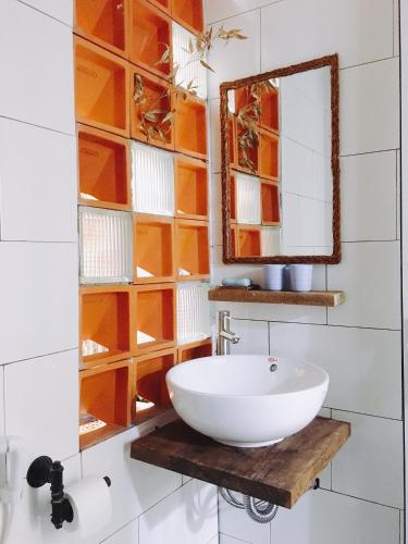 a bathroom with a white sink and a mirror at The Kadupul Homecation in Da Lat