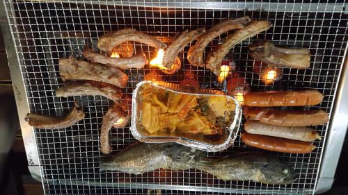a grill with sausage and sausages on it at Sunmoon Pension in Yeosu