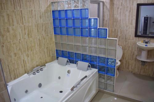 y baño con bañera, aseo y lavamanos. en Hotel Los Cristales, en Pereira