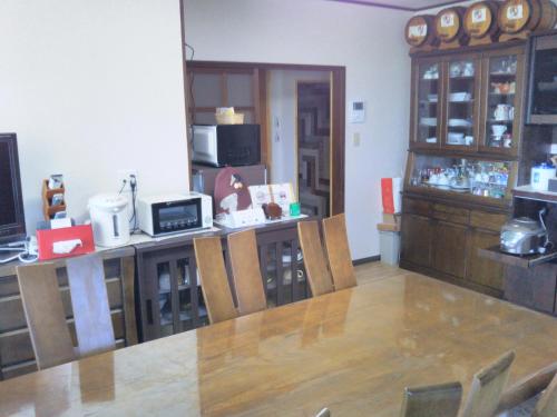 a room with a table and a counter with chairs at Guest House Hostel yukuru in Iiyama