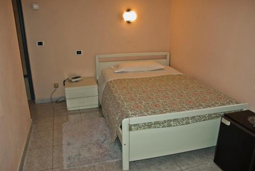 a small bedroom with a bed and a telephone at Hotel Cristallo in Lerici