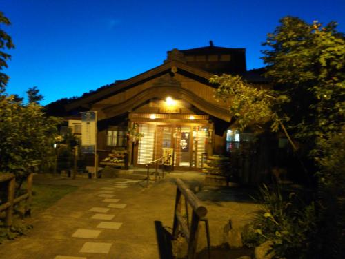 a house with a lit up facade at night at Guest House Hostel yukuru in Iiyama
