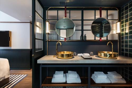 a bathroom with two sinks and mirrors on a counter at The Fleming Hong Kong in Hong Kong