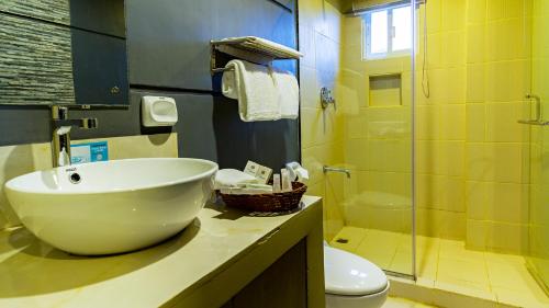 e bagno con lavandino, servizi igienici e doccia. di Vela Terraces Hotel a Coron