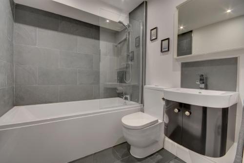 uma casa de banho com um lavatório, um WC e uma banheira em 38 George Street em Whitby