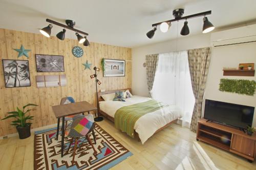 a bedroom with a bed and a desk and a tv at White Sand Beach Enoshima in Kamakura