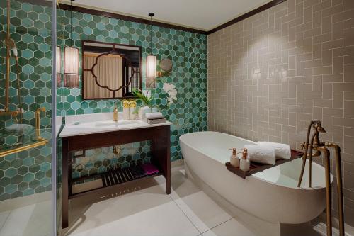 a bathroom with a tub and a sink at Little Riverside Hoi An . A Luxury Hotel & Spa in Hoi An
