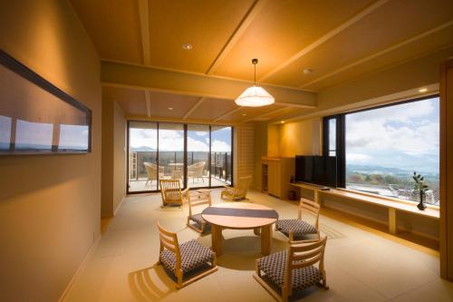 a living room with a table and chairs and a large window at Oyado Tamaki in Shibukawa
