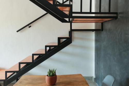 a black spiral staircase in a room with a table at Gallo Azul, Downtown Loft Style Apartment in Todos Santos
