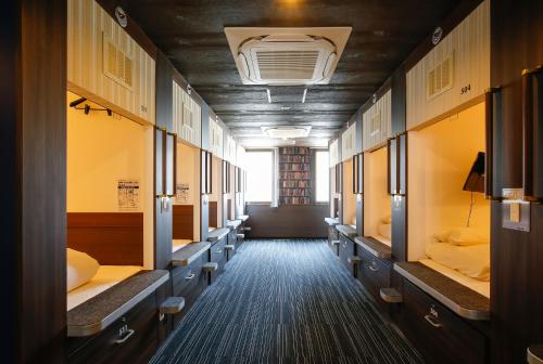 a hallway with rows of beds in a room at Sejour Inn Capsule in Hiroshima