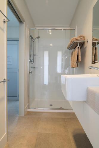a bathroom with a shower and a white sink at Cooper's Country Lodge in Eromanga