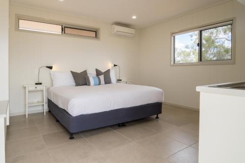 Un dormitorio con una cama grande y una cocina. en Cooper's Country Lodge, en Eromanga